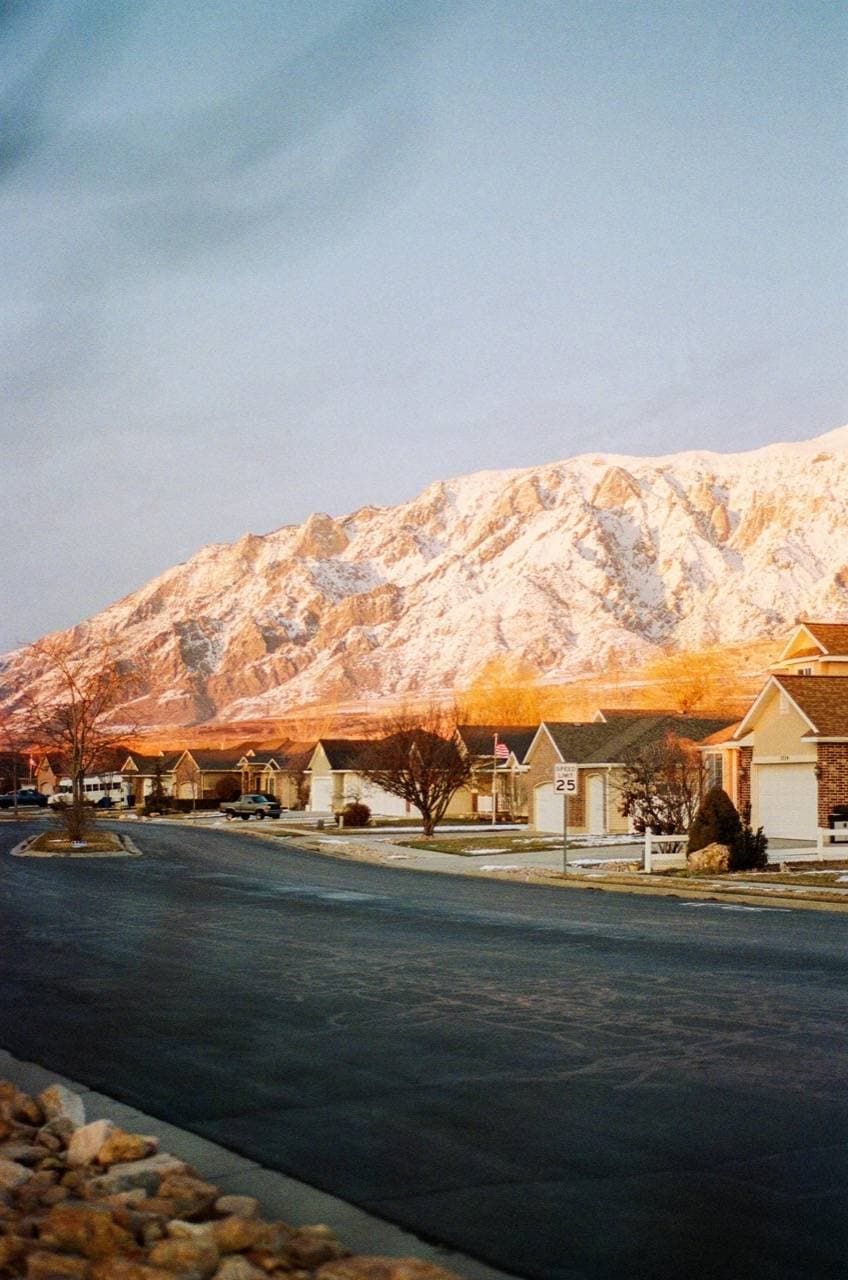 A suburban street of single-family homes at first light.